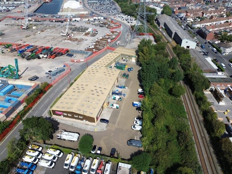 A modern unit of approximately 4,865 ft² arranged as a ground floor warehouse with roller shutter access, with additional first floor offices and Photo 11