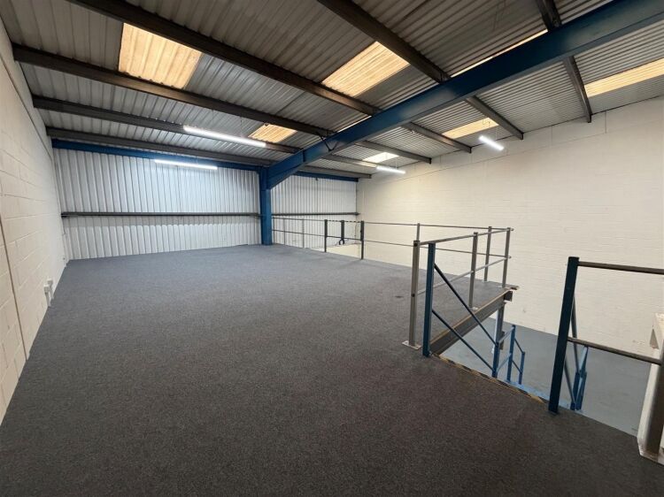 A modern unit of approximately 4,865 ft² arranged as a ground floor warehouse with roller shutter access, with additional first floor offices and Photo 11