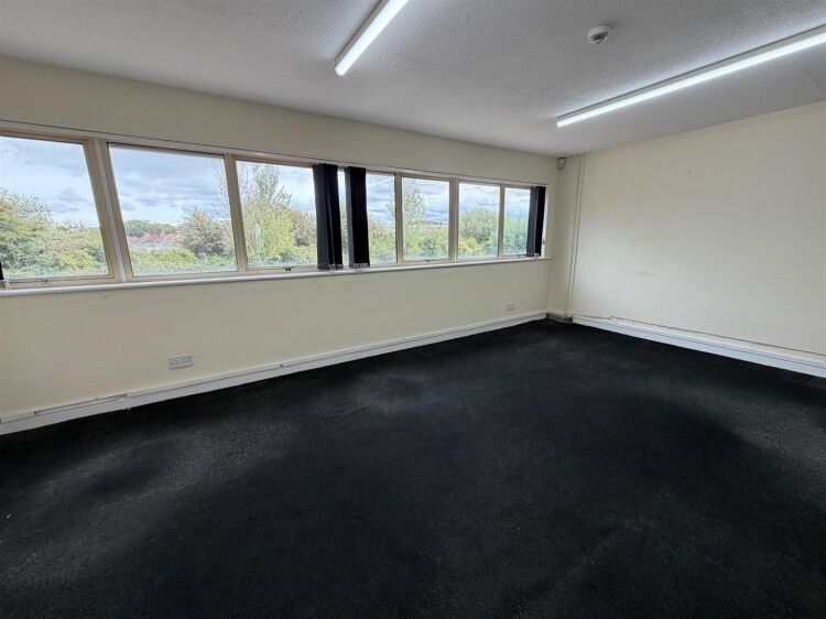 A modern unit of approximately 4,865 ft² arranged as a ground floor warehouse with roller shutter access, with additional first floor offices and Photo 12