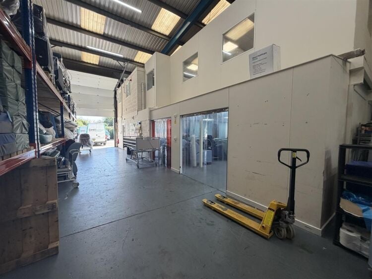 A modern unit of approximately 4,865 ft² arranged as a ground floor warehouse with roller shutter access, with additional first floor offices and Photo 2