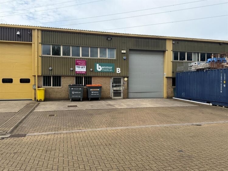 A modern unit of approximately 4,865 ft² arranged as a ground floor warehouse with roller shutter access, with additional first floor offices and Photo 2