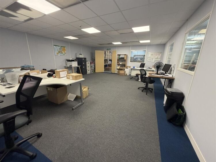 A modern unit of approximately 4,865 ft² arranged as a ground floor warehouse with roller shutter access, with additional first floor offices and Photo 4
