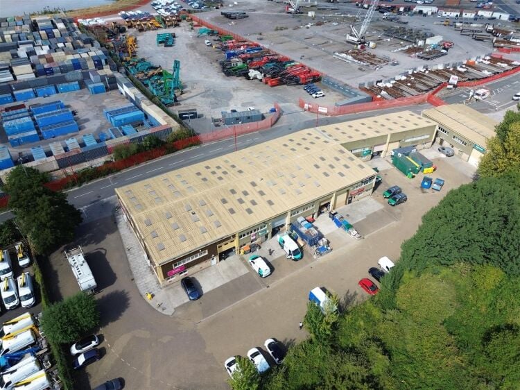A modern unit of approximately 4,865 ft² arranged as a ground floor warehouse with roller shutter access, with additional first floor offices and Photo 5