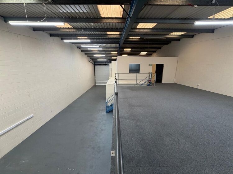 A modern unit of approximately 4,865 ft² arranged as a ground floor warehouse with roller shutter access, with additional first floor offices and Photo 6