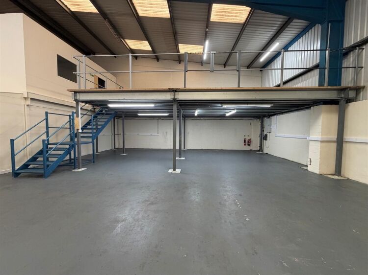 A modern unit of approximately 4,865 ft² arranged as a ground floor warehouse with roller shutter access, with additional first floor offices and Photo 7
