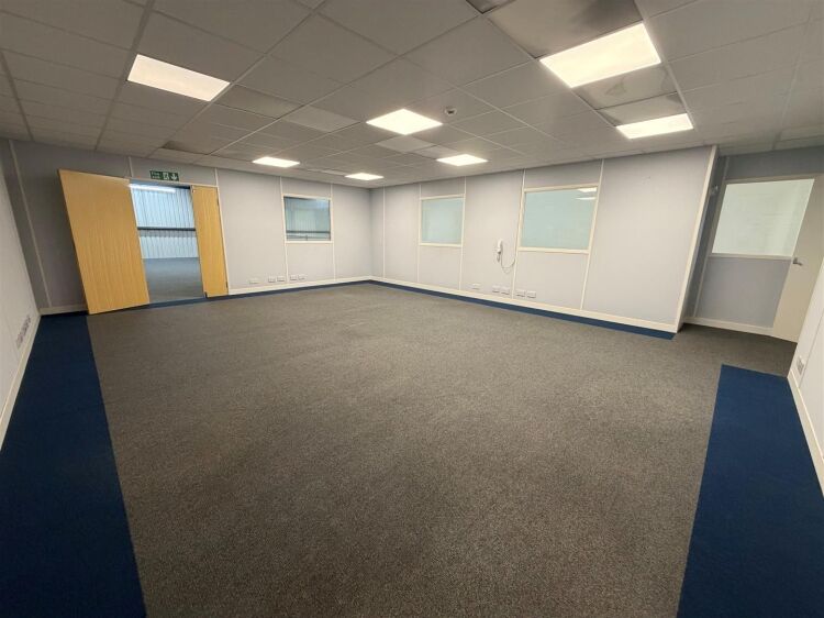 A modern unit of approximately 4,865 ft² arranged as a ground floor warehouse with roller shutter access, with additional first floor offices and Photo 8