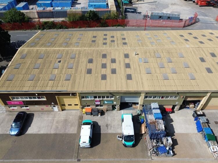 A modern unit of approximately 4,865 ft² arranged as a ground floor warehouse with roller shutter access, with additional first floor offices and Photo 9